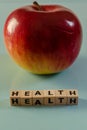 The word health written in cubes and an apple Royalty Free Stock Photo