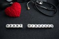 Word heart diseases from white cubes with letters on dark background with red thread heart and tonometer. Heart cardiovascular di