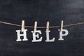 Word HELP with clothespins on black background. Inscription from white letters Royalty Free Stock Photo