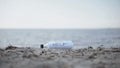 Word Help in glass bottle lying on beach, mystery message of shipwreck survivors