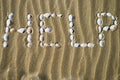 The word Help made of white seashells on sand. Royalty Free Stock Photo