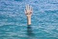 Word help written on the palm of a sinking hand in ocean`s water. Drowning person Emergency failure and help concept