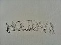 The word holiday written in the sand at the beach on shore Royalty Free Stock Photo