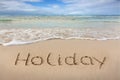 Word Holiday written on the sand near the sea. Royalty Free Stock Photo