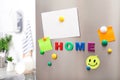 Word HOME of magnetic letters and paper sheets on refrigerator door indoors Royalty Free Stock Photo