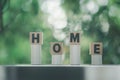 The word HOME is written in black letters placed on wood block stick