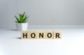 The word Honor written in vintage wooden cubes on a white background Royalty Free Stock Photo