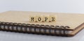 Word HOPE made with letters on wooden blocks on wooden notepad Royalty Free Stock Photo