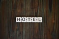 Word hotel written with white plastic letters on a wooden surface