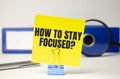 word how to stay focused on yellow sticker and blue folder Royalty Free Stock Photo