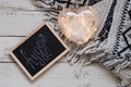 Word hygge written on a blackboard, heart shaped lantern for home decoration and blanket