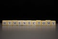 The word HYMENECTOMY written on wooden cubes, isolated on a black background Royalty Free Stock Photo