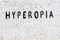 Word hyperopia painted on white brick wall