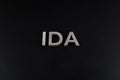 the word ida laid with silver metal letters over dry black matte surface Royalty Free Stock Photo