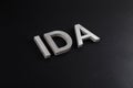 the word ida laid with silver metal letters over dry black matte surface Royalty Free Stock Photo