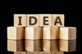 Word IDEA on wooden cubes on a glossy black background Royalty Free Stock Photo