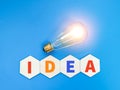 Word IDEA on wooden hexagon with glowing light bulb. Royalty Free Stock Photo