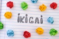 The word Ikigai on notebook sheet with some colorful crumpled paper balls around it