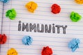 The word Immunity on notebook sheet with some colorful crumpled paper balls around it Royalty Free Stock Photo