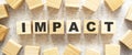 The word IMPACT consists of wooden cubes with letters, top view on a light background Royalty Free Stock Photo