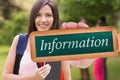 Information against pretty student smiling at camera outside on campus Royalty Free Stock Photo