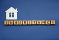 Word Inheritance made with wooden cubes and house model on blue background, flat lay Royalty Free Stock Photo