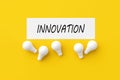 The word innovation on white paper with light bulbs. Innovation and technological creativity or development in business Royalty Free Stock Photo