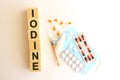 The word IODINE is made of wooden cubes on a white background. Medical concept