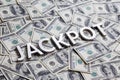The word JACKPOT laid with aluminium letters on the US dollar banknotes background - with selective focus