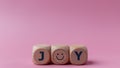 Word joy on wooden blocks with a smiling face symbol. Joy, happiness, pleasure, joyful emotion Royalty Free Stock Photo