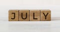 The word July on wooden cubes. Concept Month of year