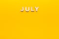 Word July on yellow background