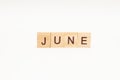 Word JUNE made of wooden blocks on white background. Month of year