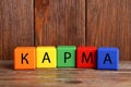 Word Karma made of colorful cubes with letters on wooden table Royalty Free Stock Photo