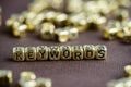 Word KEYWORD made from small golden letters on the brown backgro Royalty Free Stock Photo