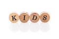 Word Kids from circular wooden tiles with letters children toy. Royalty Free Stock Photo