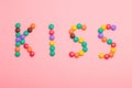 The word KISS is written by sweet colorful chocolate candy on pink background Royalty Free Stock Photo