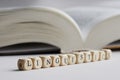 Word linguistics from wooden cubes on white background next to an open book. Concept of studying linguistics and sciences about