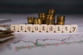 Word LIQUIDITY composed of wooden letter. Stacks of coins in the background Royalty Free Stock Photo