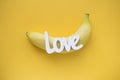 Word LOVE  and banana on yellow background Royalty Free Stock Photo