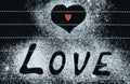 Word love on a black background. one red heart. Sprinkle with flour. Valentine`s Day Love Concept Copyspace Royalty Free Stock Photo