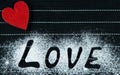 Word love on a black background. Red heart on the left side. Sprinkle with flour. Valentine`s Day. Copyspace Love Concept Royalty Free Stock Photo