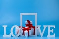 The word love, gifts and frame on a blue background Royalty Free Stock Photo