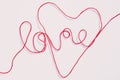 Word love and heart shape written with red yarn thread on white Royalty Free Stock Photo