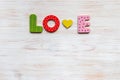 Word love is made of colorful wooden letters and heart on white textured wooden background, top view, copy space Royalty Free Stock Photo