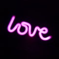 The word love in neon on dark display Royalty Free Stock Photo