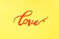 The word Love and red hearts on a yellow background, top view. Holiday card for Valentine`s Day. Flat lay Royalty Free Stock Photo