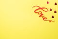 The word Love and red hearts on a yellow background, top view. Holiday card for Valentine`s Day. Flat lay Royalty Free Stock Photo