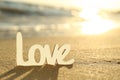 Word Love on sandy beach at sunset, closeup. Wedding concept Royalty Free Stock Photo