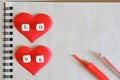 The word love and two red silk hearts, together with a fountain pen, lie on a notebook made of ecological paper. Blank for Royalty Free Stock Photo